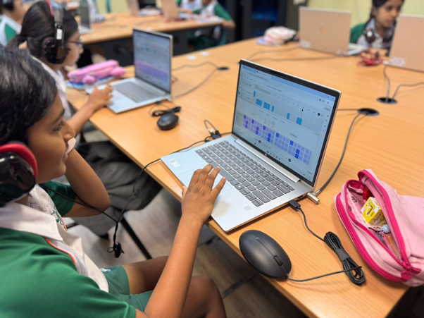 Student creating music on a laptop during a digital music learning activity.